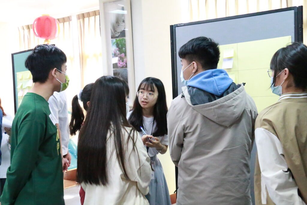 團隊夥伴在便利貼牆前帶領小組討論
